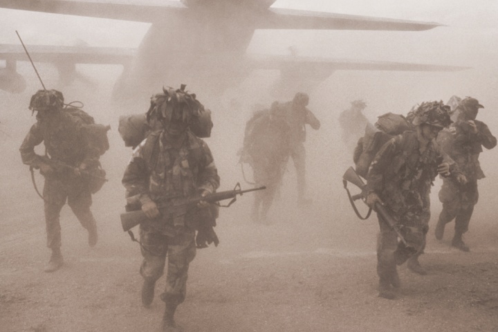 Soldiers coming out of an airplane.