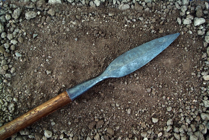 A spear lying on the dirt.