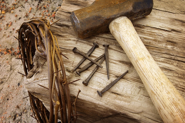 A crown of thorns, nails, hammer and post.