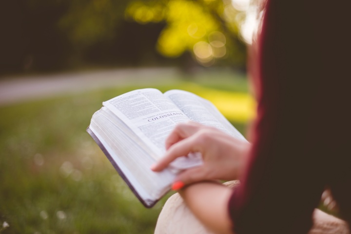 A woman holding a Bible on her lap.