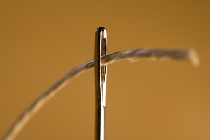 A thread going through the eye of a needle.