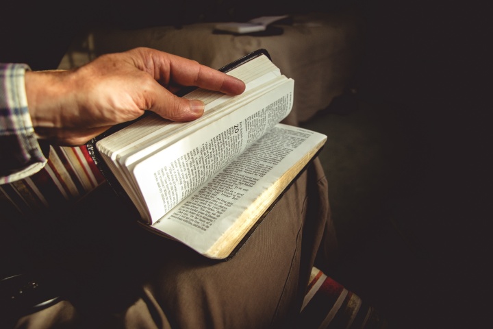 A man holding an open Bible.