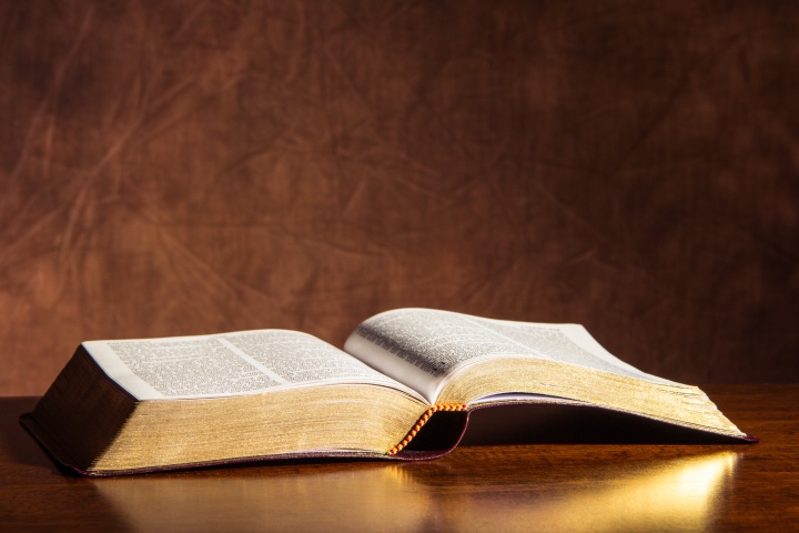 An open Bible laying on a table.