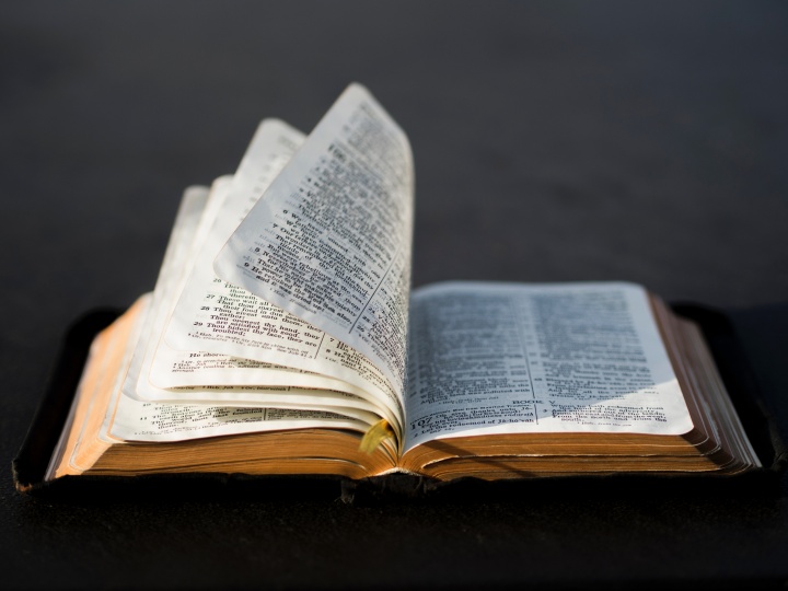 An open Bible laying on a table.