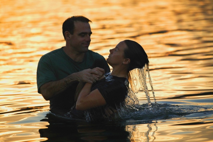 A scene of a person getting fully submersed in a water baptism.