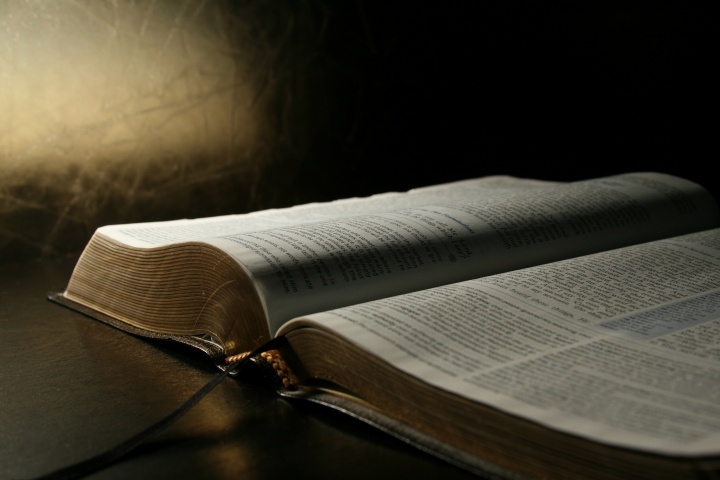 An open Bible laying on a table.