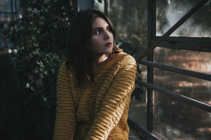 A young woman looking out a window.