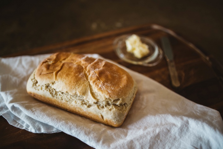 A small loaf of bread and a small dish of butter.