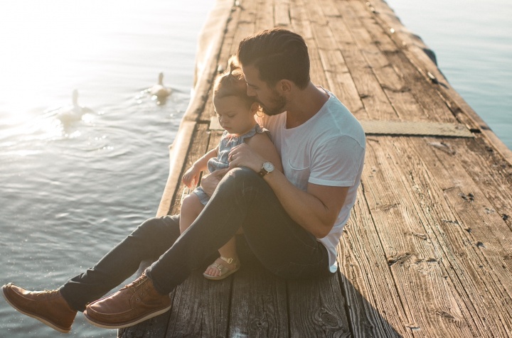 A dad sitting with his daughter.