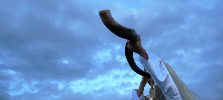 A person blowing a shofar.