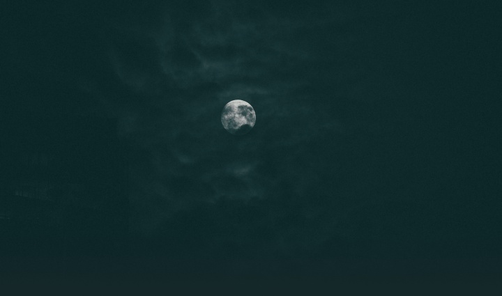 The moon through dark clouds.