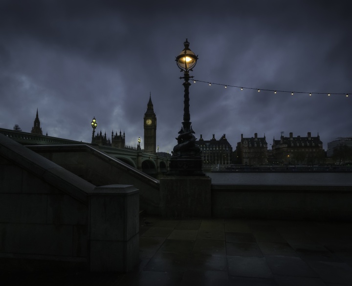 A night shot of London with Big Ben belltower in the distance.