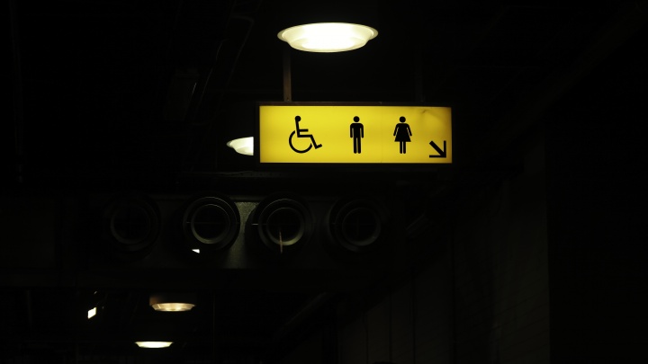A bathroom sign with icons for a man, woman and handicap.