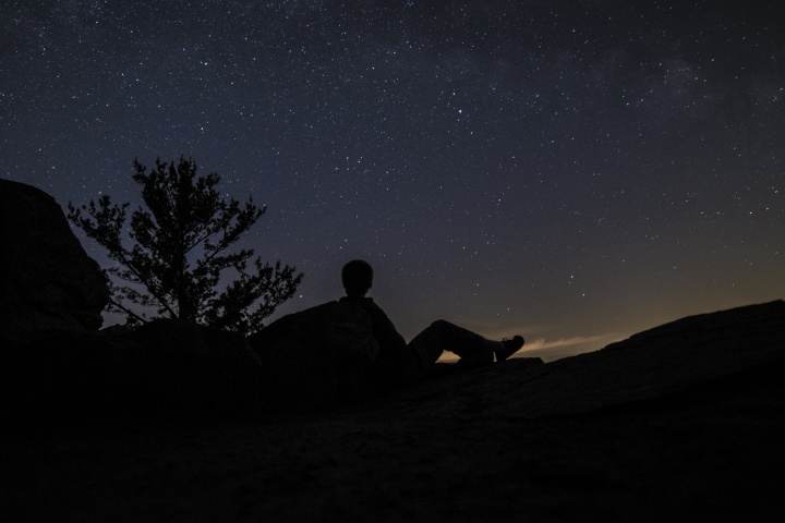 A person looking up at the millions of stars filling the night sky.