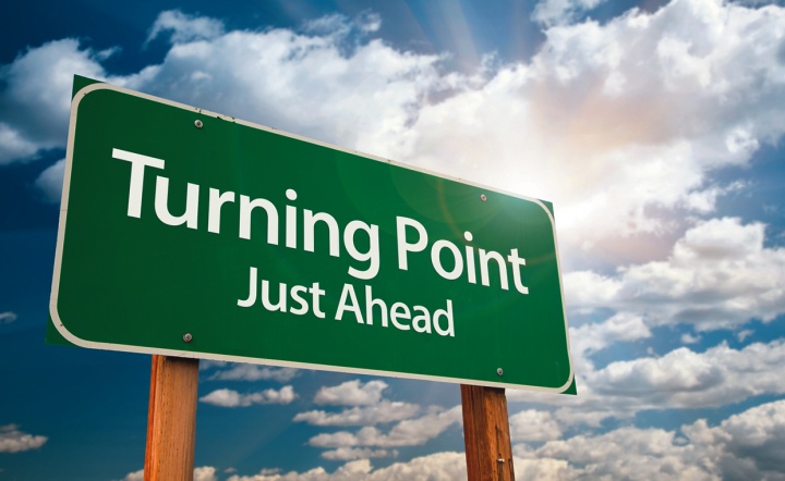 A green road sign with the words &quot;Turning Point: Just Ahead&quot;.