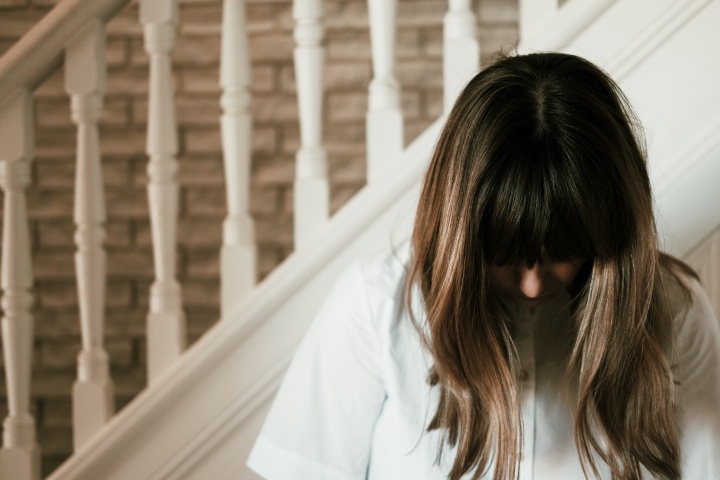 A woman with head bowed in prayer.