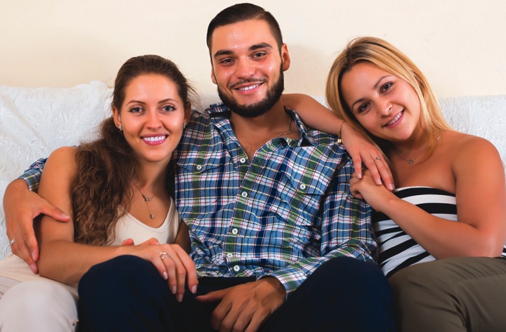 A man sitting with two women.