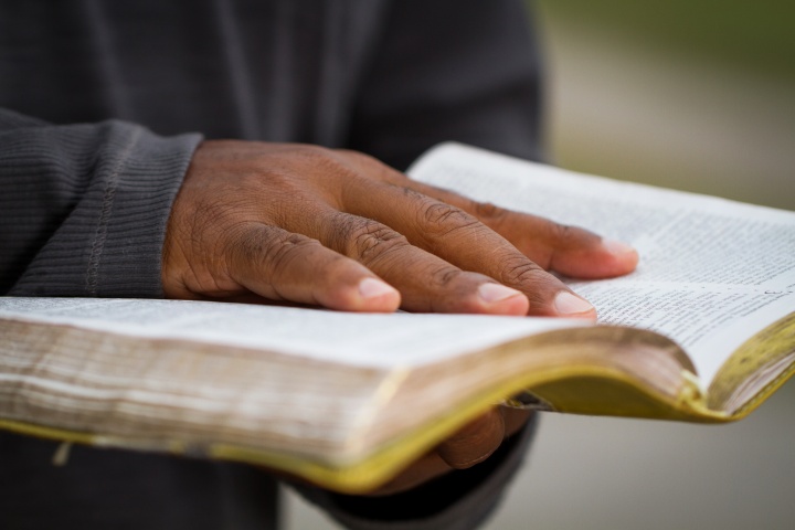 A man holding an open Bible.