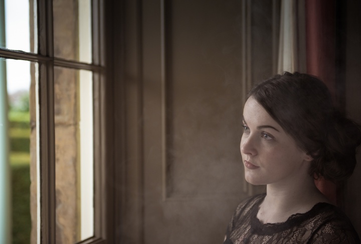 A young woman looking out a window.