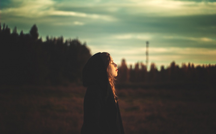 A young woman looking up at the sky.