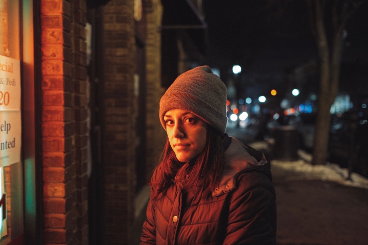 A young woman standing outside a store.