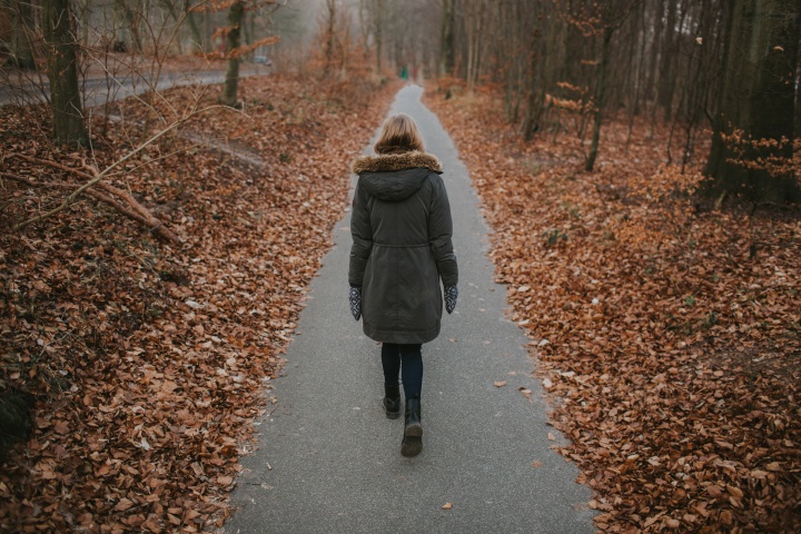 A woman walking on a paved path.