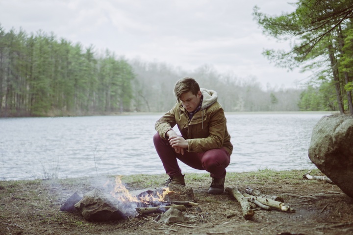 A man sitting by a campfire.