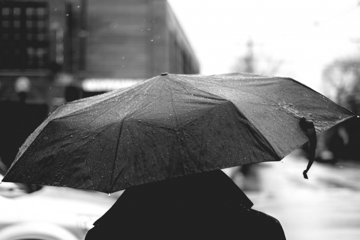 A person walking in the rain using an umbrella.