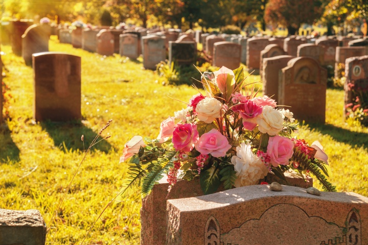 Headstones and flowers at a cemetery. 