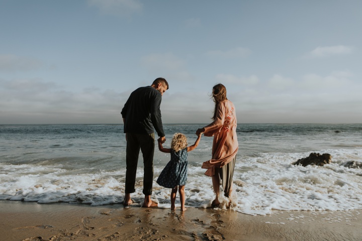 A family wading in the waves of the ocean.