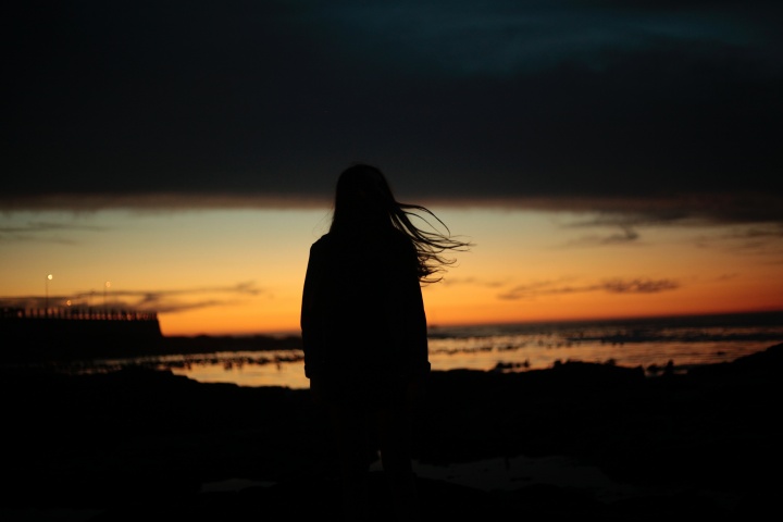 A silhouette of woman at sunset.