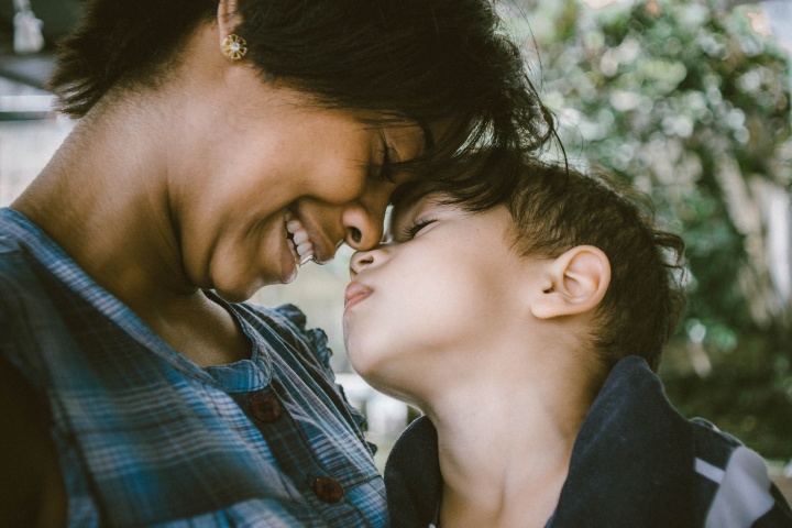 A mother and child touching foreheads. 