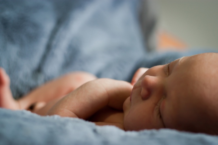 New born baby lying on a blanket.