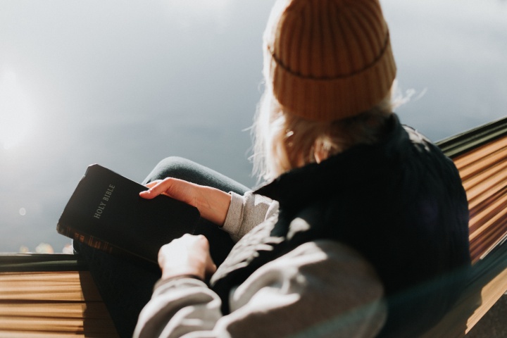 A woman holding a Bible on her lap.