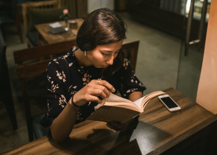 A woman reading a book in a cafe.