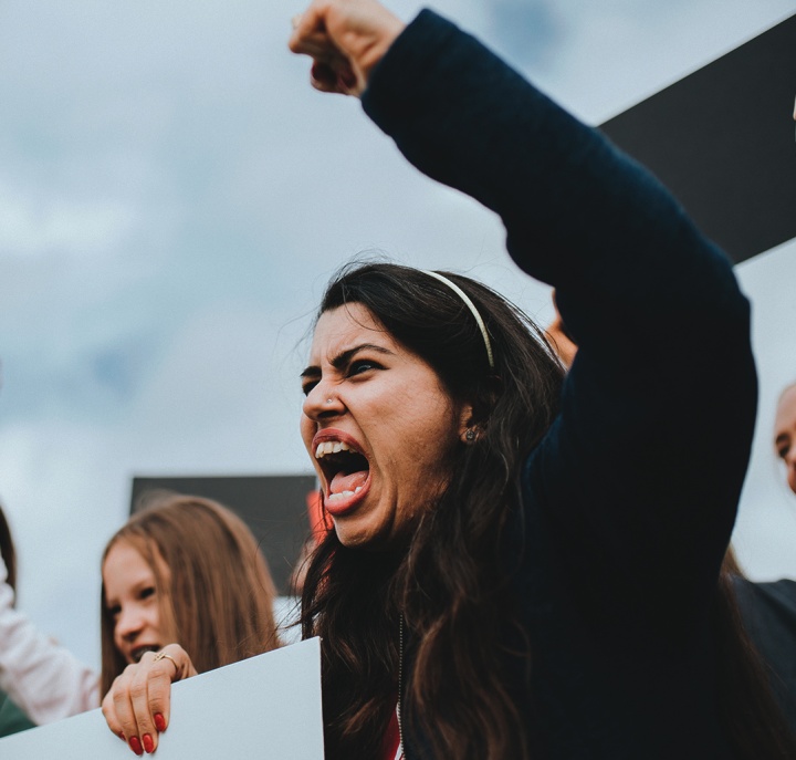 An angry woman screaming with her fist in the air.