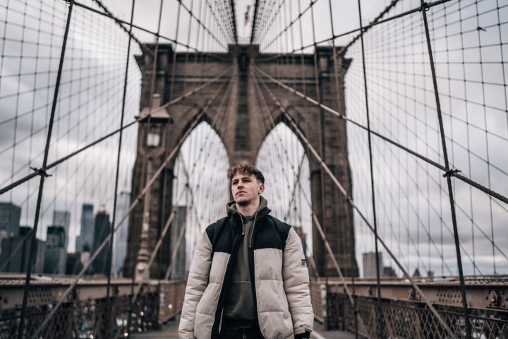 A man walking on the Brooklyn Bridge.