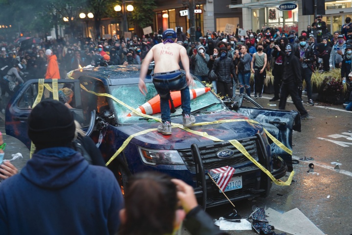 Rioters destroy a police vehicle in Seattle.