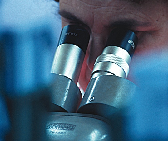 A scientist using a microscope.