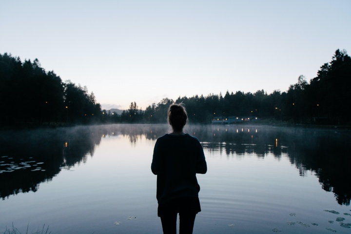 A woman looking at a lake.