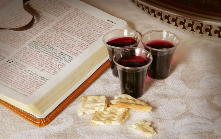 An open Bible with Passover wine an pieces of unleavened bread.