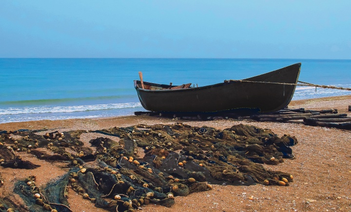 A boat on a sandy shore with nets.