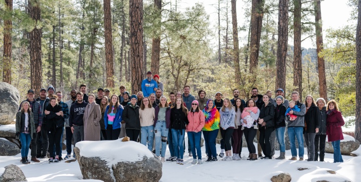 A group of young adults standing in the snow