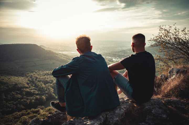 Two people sitting outdoors looking over a landscape