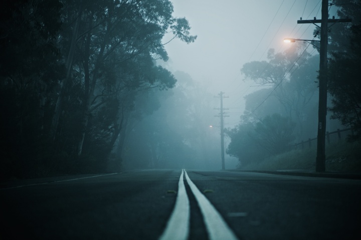 a road a twilight leading into the fog