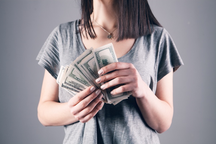 a woman holding one-hundred dollar notes