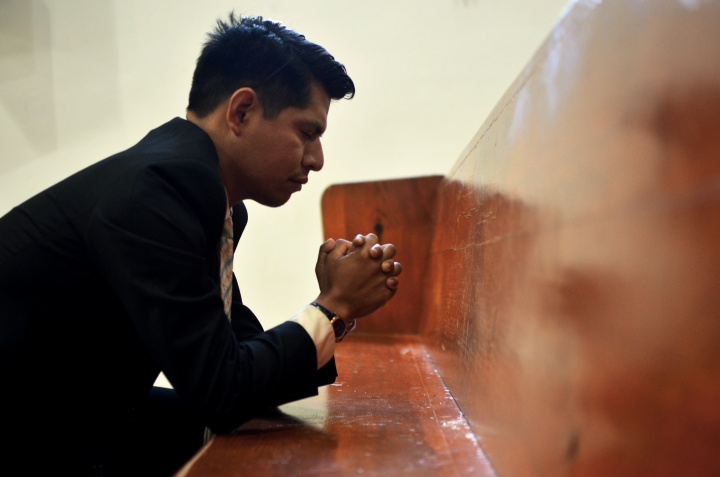 a man with hands folded in prayer