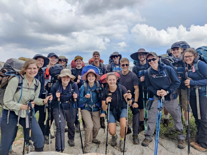 a group of hikers with gear against a mountain backdrop