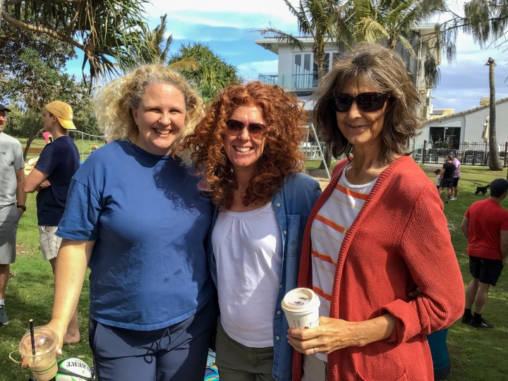 three ladies smiling as they stand outdoors