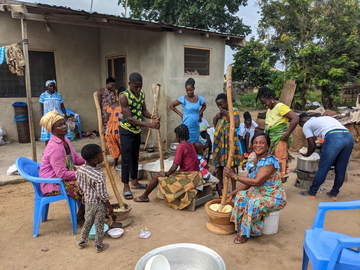 a group of brethren sitting outside a house in Ghana